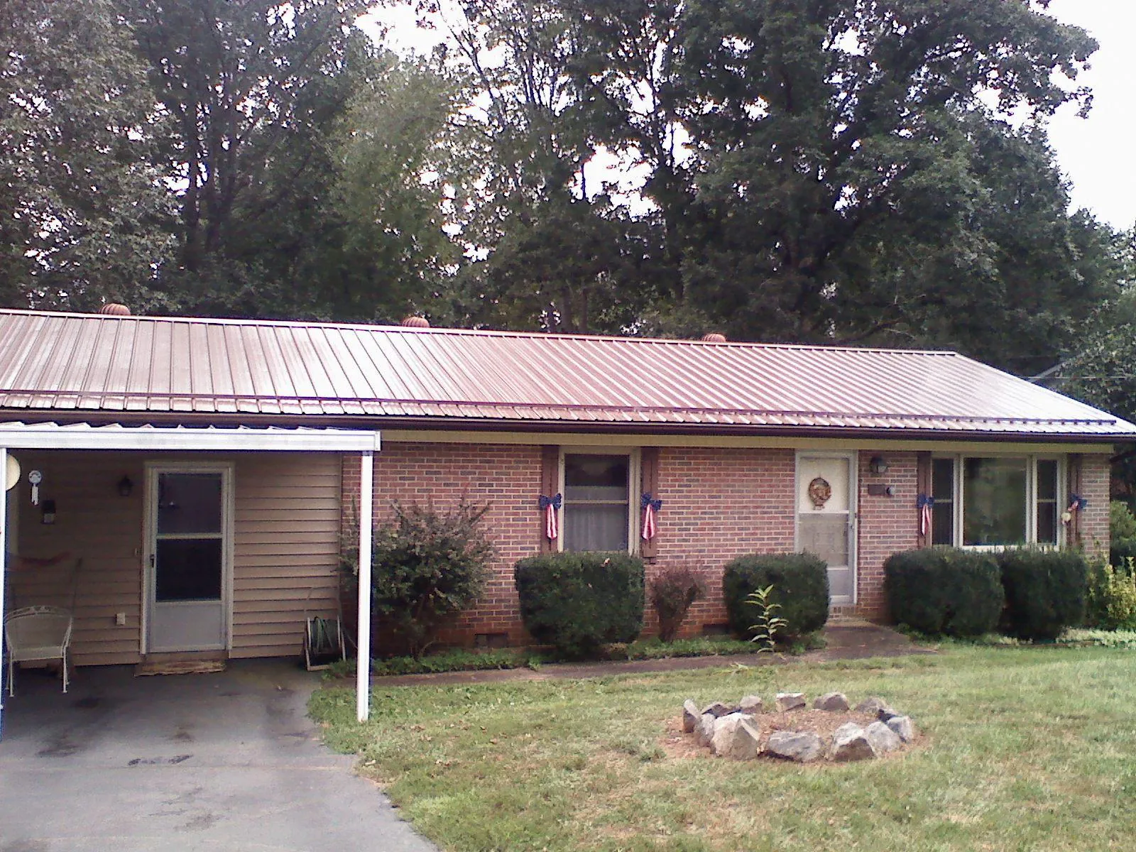 Bronze metal roof and carport on a brick ranch home — Roof Repair work by our crew in Powder Springs